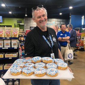 Tony holding a tray of donuts