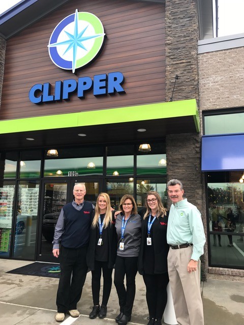 People posing for picture in front of Clipper store