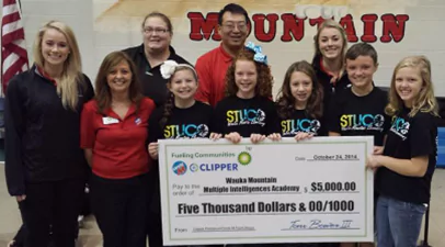 Group of children holding big check