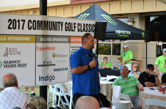 Man speaking on microphone at 2017 Community Golf Classic